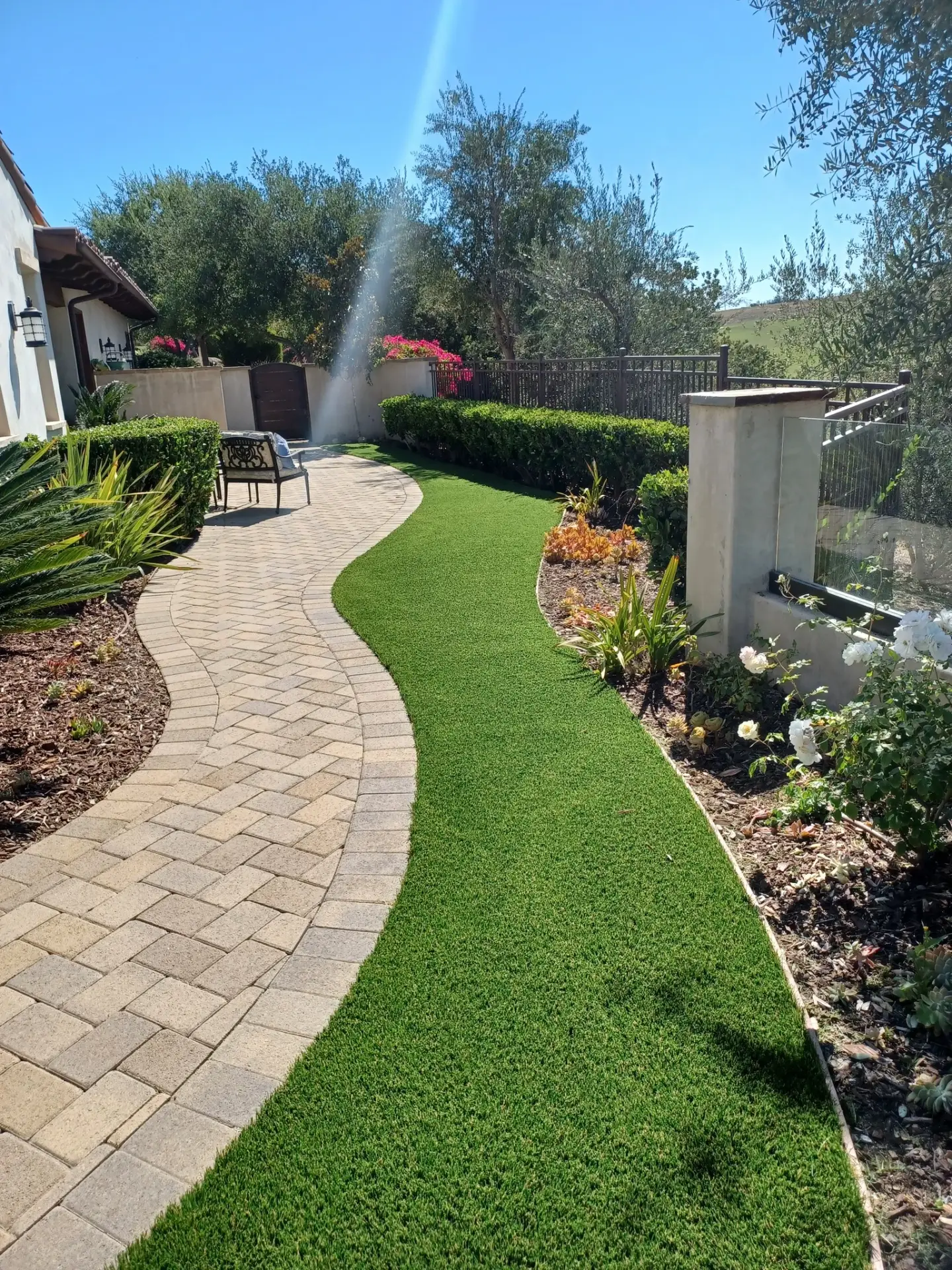 Precision interlocking paver systems with edge restraint stabilization and polymeric sand joints to inhibit weed growth and maintain structural alignment under thermal expansion.